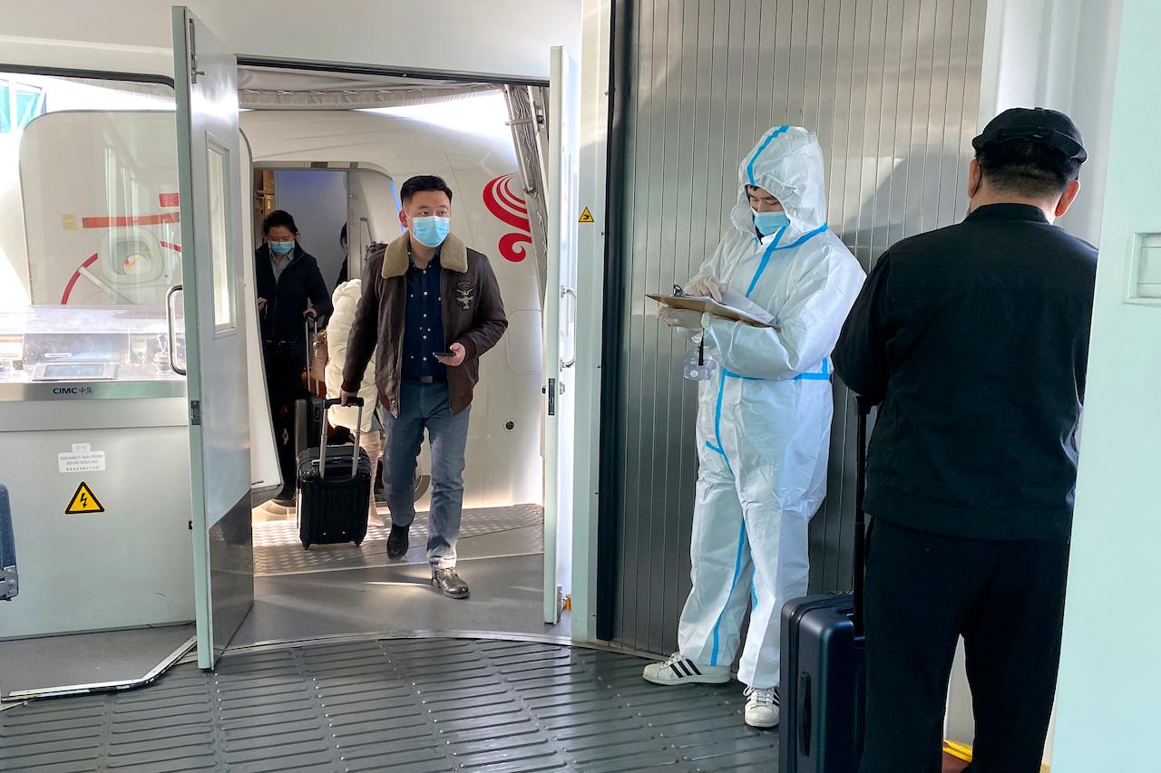Passengers wearing face masks to protect against the spread of the coronavirus exit a plane after arriving at Wuhan Tianhe International Airport in Wuhan in central China's Hubei Province, Jan 14. Photo: AP