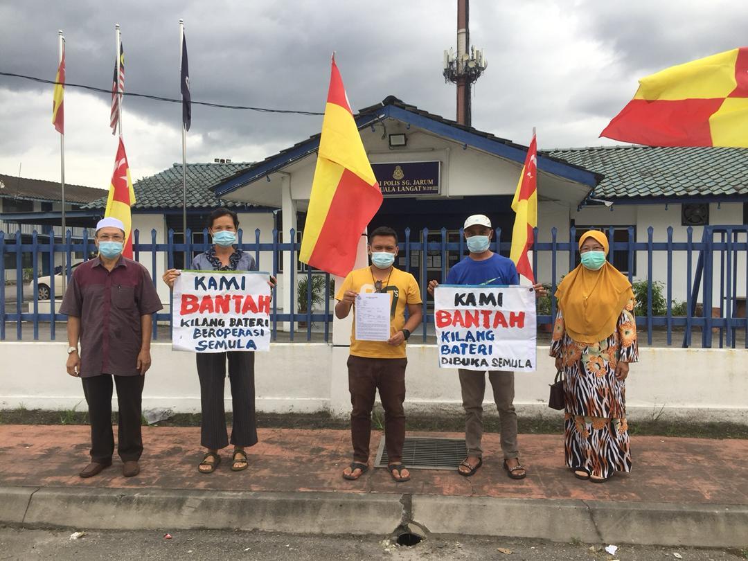 Residents in Jenjarom, Selangor hold up signs protesting against the resumption of operations at a battery manufacturing plant shut down by the state government in 2019.