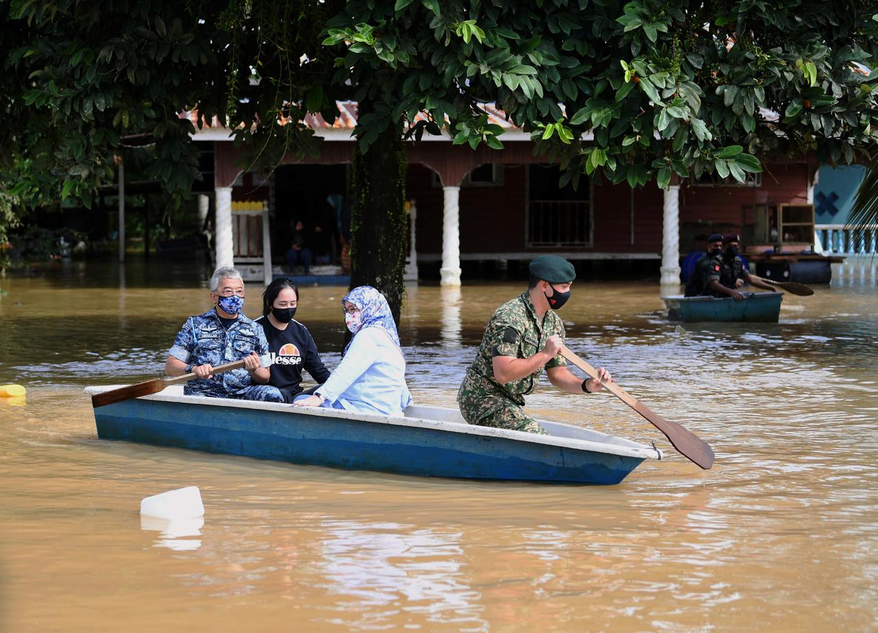 Yang di-Pertuan Agong Sultan Abdullah Sultan Ahmad Shah mendayung sendiri sampan ketika meninjau situasi banjir di daerah Pekan, Pahang hari ini. Gambar: Bernama