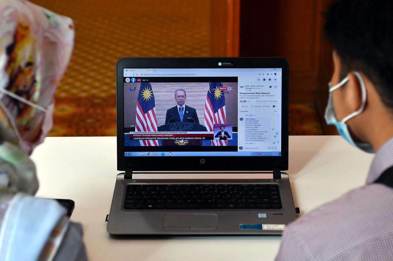 Members of the public watch Prime Minister Muhyiddin Yassin's live address to the nation on Jan 12 regarding the state of emergency declared until Aug 1. Photo: Bernama