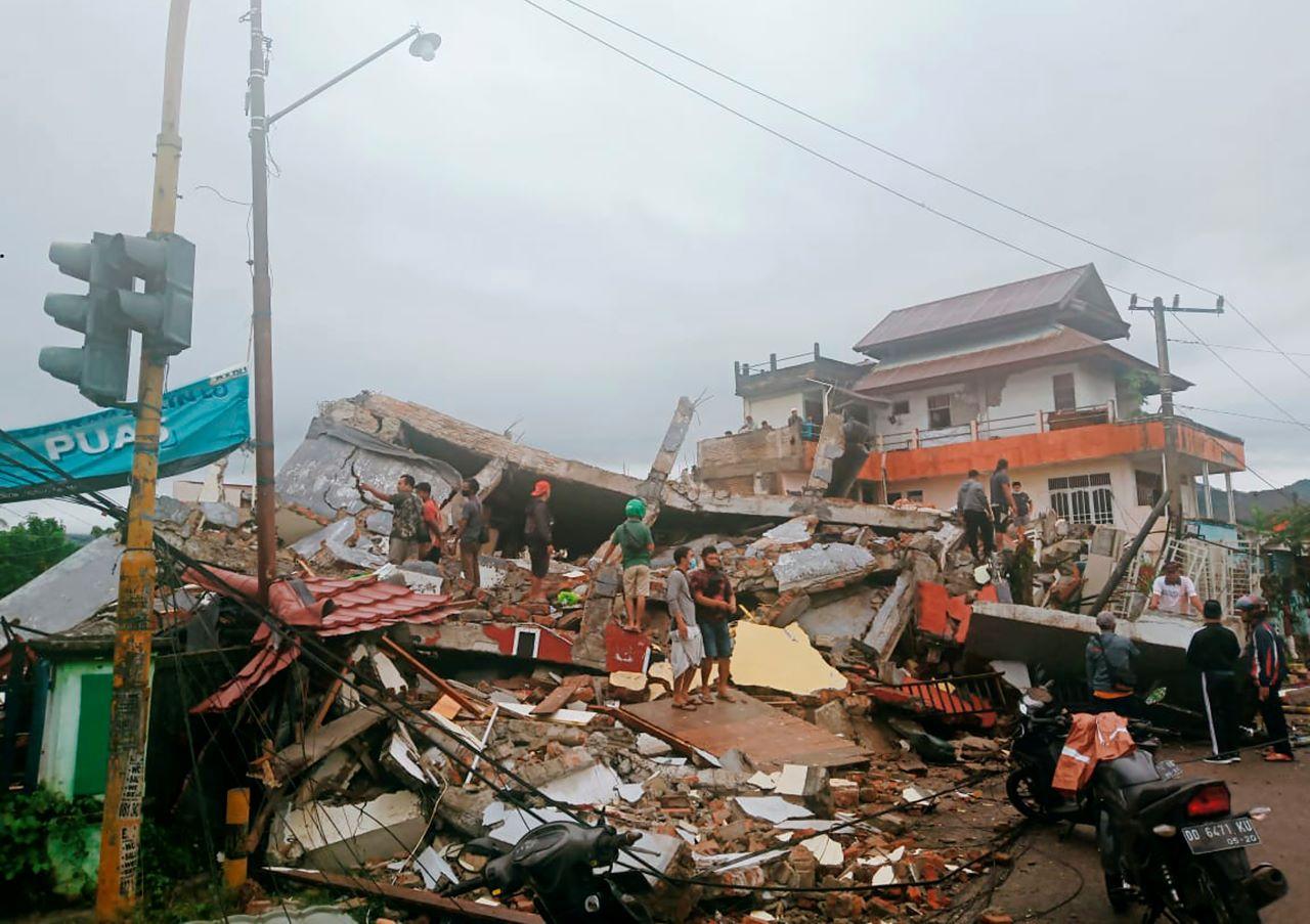 Residents inspect earthquake-damaged buildings in Mamuju, West Sulawesi, Indonesia, Jan 15. Photo: AP