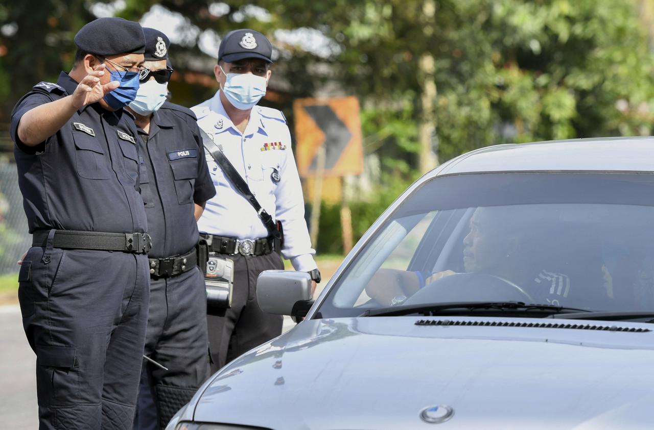 Ketua Polis Kelantan Shafien Mamat (kiri) bertanyakan sesuatu kepada pemandu kenderaan ketika mengadakan lawatan di lokasi Sekatan Jalan Raya (SJR) di Bukit Yong hari ini. Gambar: Bernama