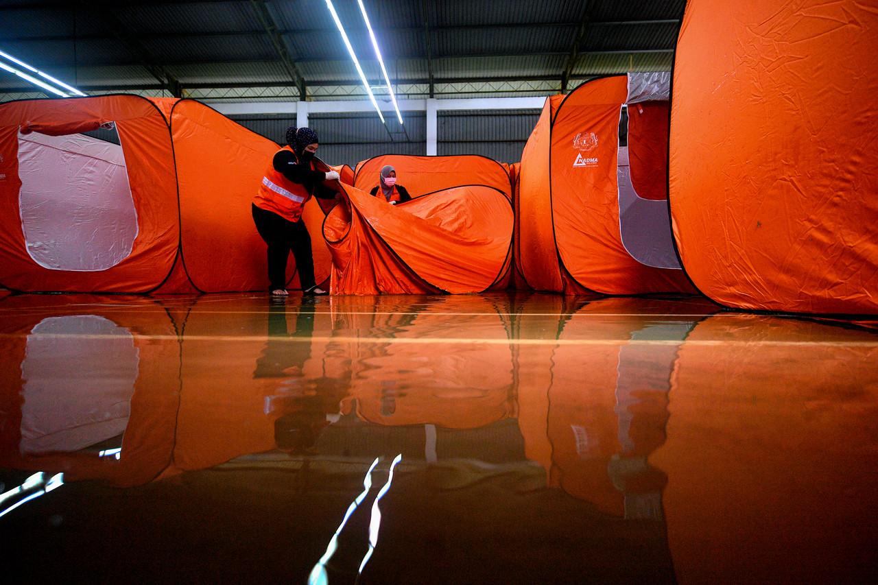 Sukarelawan Jabatan Kebajikan Masyarakat Sarawak melipat semula khemah di Pusat Pemindahan Sementara (PPS) di Dewan Taman Malihah setelah pusat itu dinaiki air pagi kelmarin. Gambar: Bernama