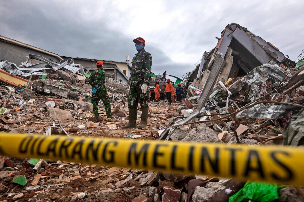 Rescuers search for victims at the ruin of a building flattened during an earthquake in Mamuju, West Sulawesi, Indonesia, Jan 16. Photo: AP