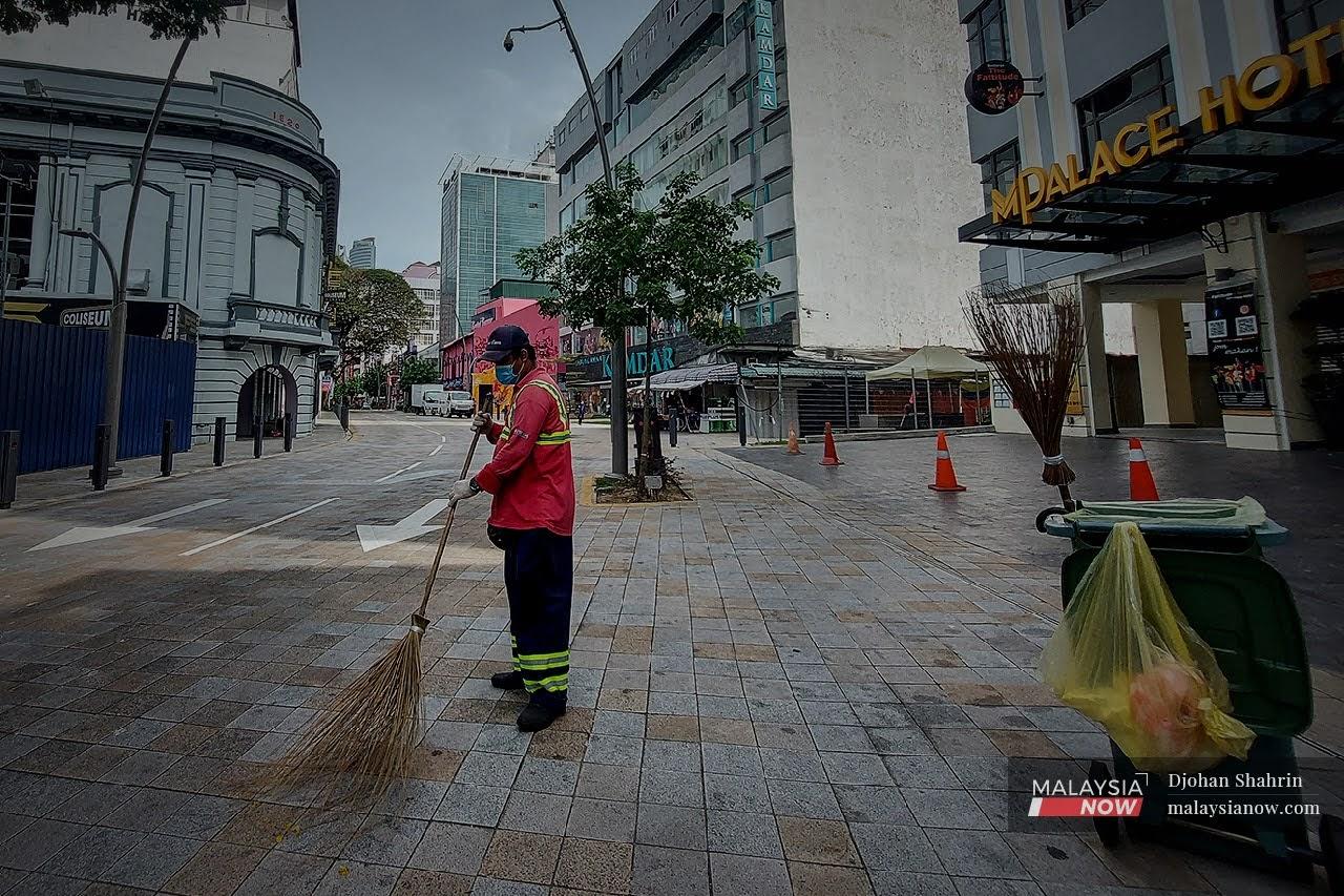 Seorang pekerja dilihat melakukan kerja-kerja pembersihan di Jalan Tuaku Abdul Rahman, Kuala Lumpur. Jalan itu kelihatan lengang selepas Perintah Kawalan Pergerakan 2.0 dilaksanakan.
