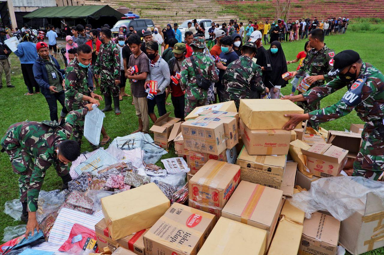 Indonesian soldiers distribute relief goods for those affected by the earthquake at a stadium in Mamuju, West Sulawesi, Indonesia, Jan 17. Photo: AP