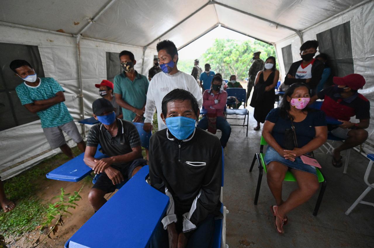 Ticuna indigenous people wait to receive the Covid-19 vaccine produced by China's Sinovac Biotech, during the start of the vaccination plan on indigenous lands at the Ticuna de Umariacu village health post in Tabatinga, Amazonas state, Brazil, Jan 19. Photo: AP