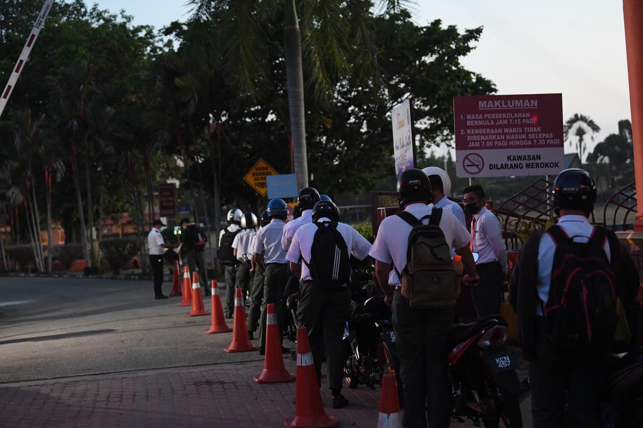 Students at SMK Dato Syed Omar in Alor Setar, Kedah queue at the school gate as physical classes reopen for those in Form 5 and 6 today. Photo: Bernama