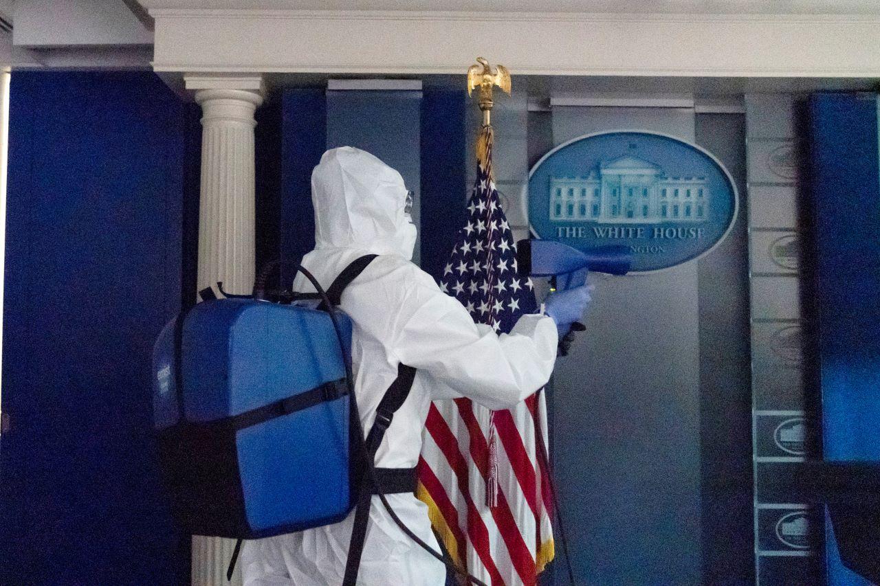 A member of the cleaning staff sprays sanitiser in a briefing room at the White House. Photo: AP