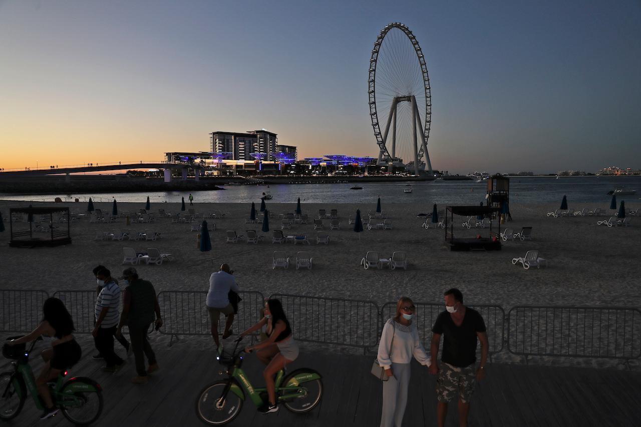 Tourists and residents enjoy the sunset at the Jumeirah Beach Residence in Dubai, United Arab Emirates, Jan 12. Coronavirus infections are surging to unprecedented heights in the UAE, but Dubai is resisting a lockdown during its peak tourism season. Photo: AP