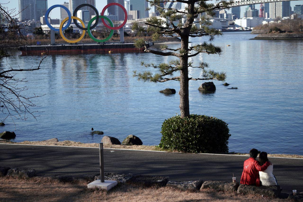 A couple sit near the Olympic rings floating in the water in the Odaiba section in Tokyo, Jan 20. The Japanese capital confirmed more than 1,200 new coronavirus cases on Wednesday. Photo: AP