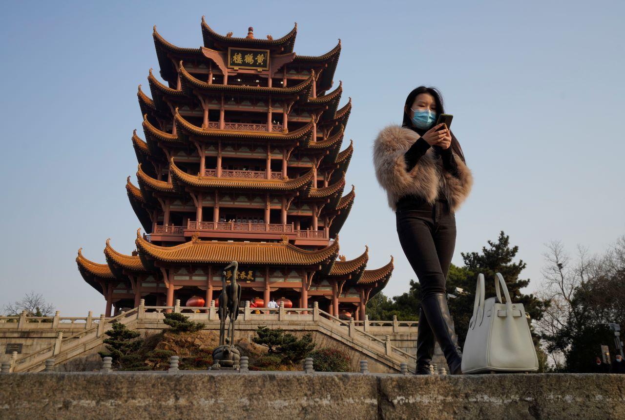 A woman wearing a mask visits the iconic Yellow Crane Tower, a popular tourist site in Wuhan in central China's Hubei province, Jan 15. Couples go on dates, families dine out at restaurants, shoppers flock to stores. Face masks aside, people are going about their daily life pretty much as before in the Chinese city that was first hit by the Covid-19 pandemic. Photo: AP