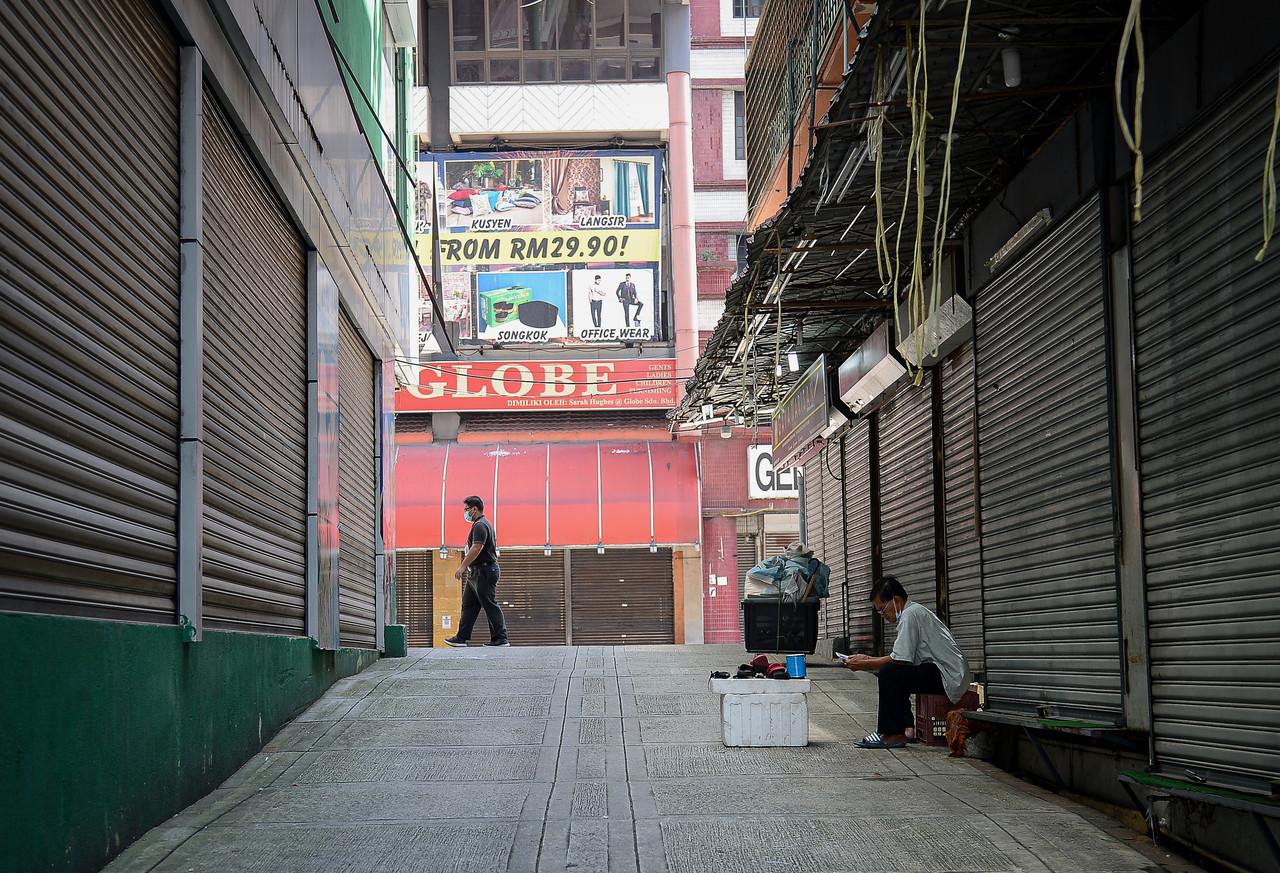 A cobbler waits for customers during the movement control order period in an alley in Kuala Lumpur today. Photo: Bernama