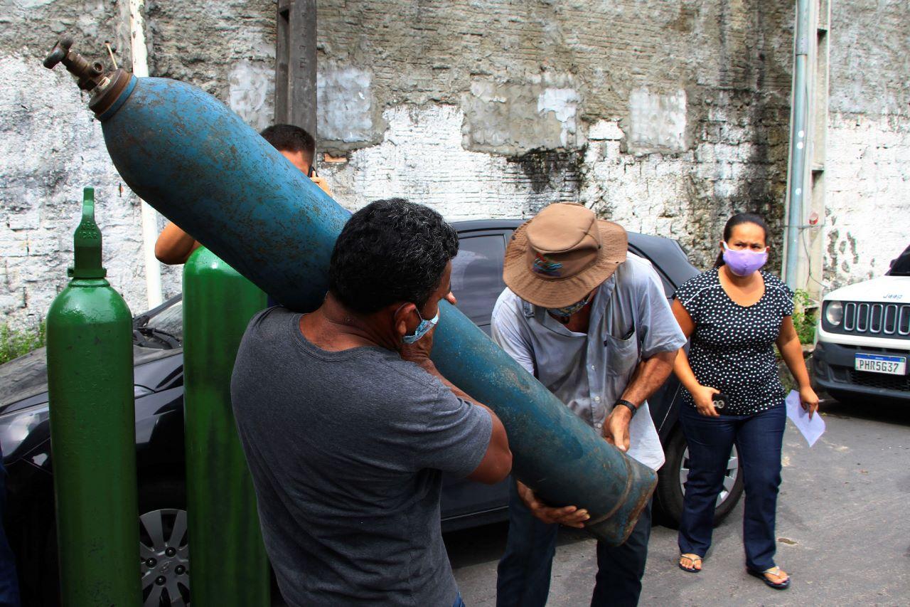 Family members of patients hospitalised with Covid-19 line up with empty oxygen tanks in an attempt to refill them, outside the Nitron da Amazonia company, in Manaus, Amazonas state, Brazil, Jan 15. Photo: AP