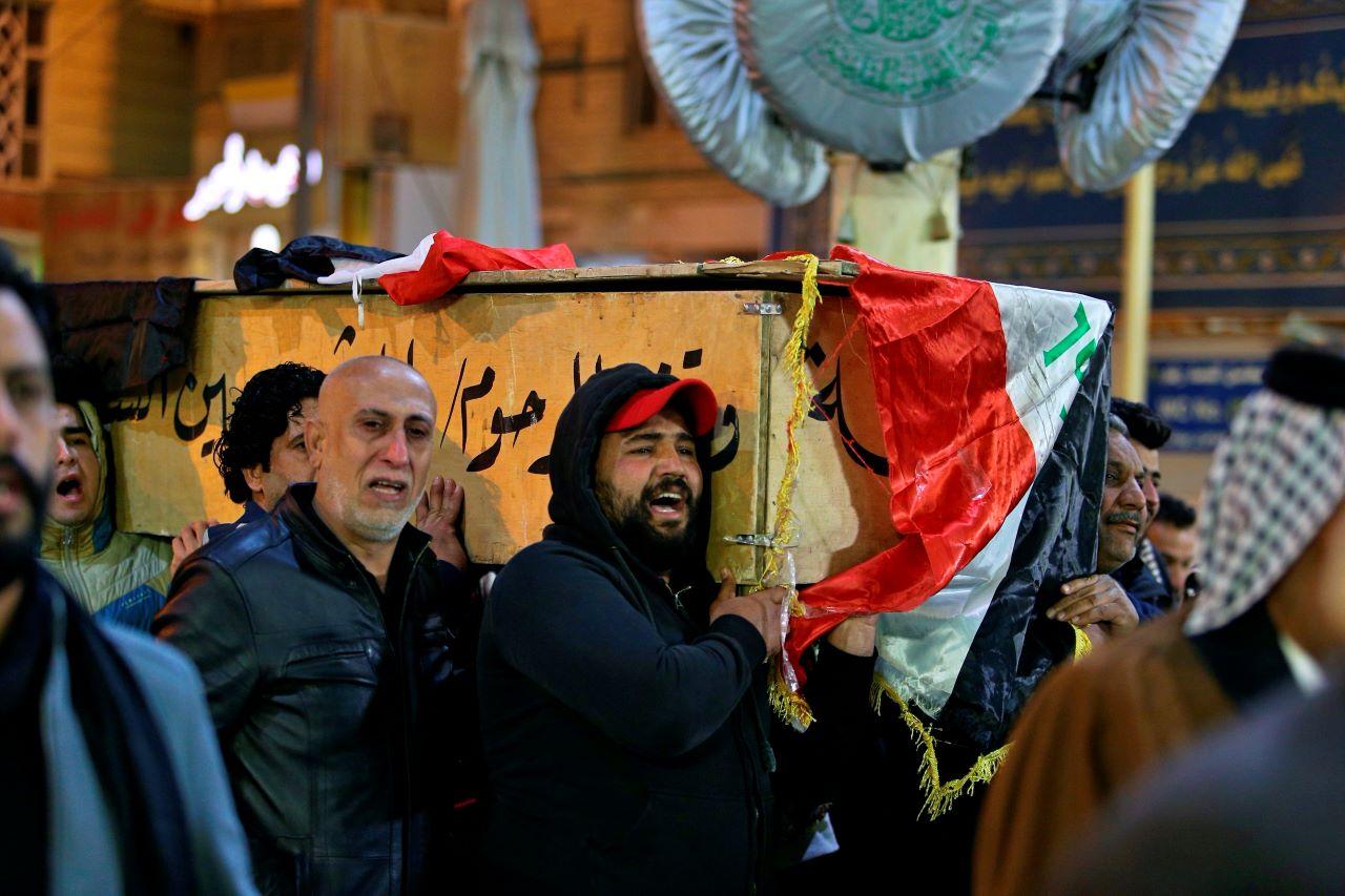 Mourners carry a flag-draped coffin of a suicide bomb victim during his funeral procession at the Imam Ali shrine in Najaf, Iraq, Jan 21. Iraq's military said twin suicide bombings at the Bab al-Sharqi commercial area in central Baghdad Thursday ripped through the busy market killing over two dozen and wounding over 70, with some in serious condition. Photo: AP