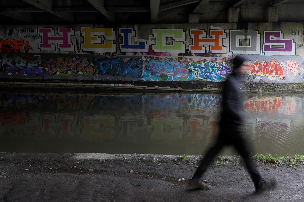 A pedestrian passes graffiti scribbled on the walls of a tunnel on the Grand Union Canal in London, Jan 21. The UK is in its third national lockdown with people told to stay at home. Photo: AP