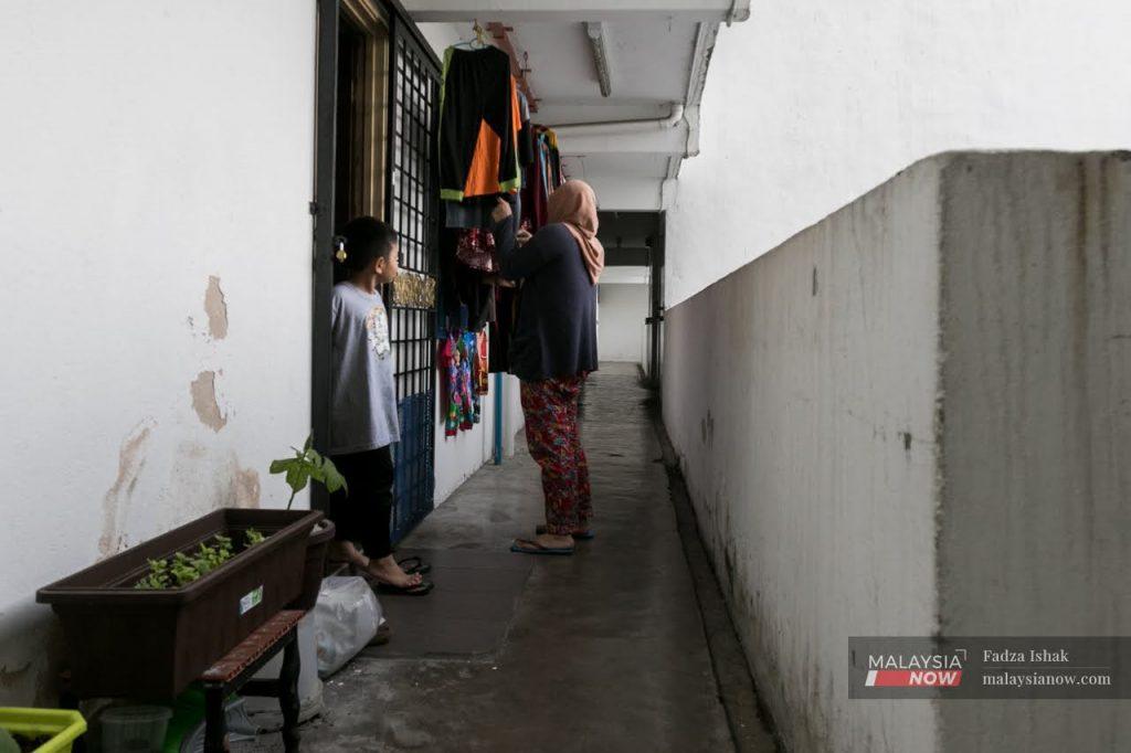 A woman checks her laundry at a low-cost flat in Pantai Dalam, Kuala Lumpur. The Covid-19 pandemic has had a heavy impact on the vulnerable poor.