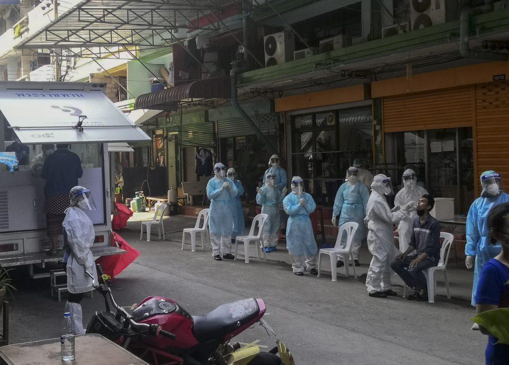 A health worker in protective gear collects a nasal swab sample from a man to test for Covid-19 in Samut Sakhon, south of Bangkok, Dec 20. Photo: AP