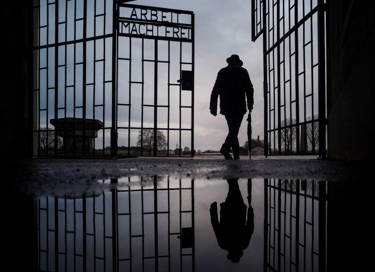 A man walks through the gate of the Sachsenhausen Nazi death camp with the phrase 'Arbeit macht frei' (work sets you free) in Oranienburg, Germany, on International Holocaust Remembrance Day. Photo: AP