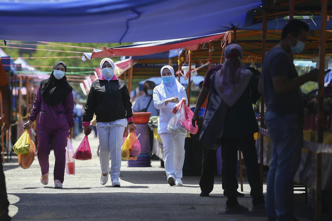 Nurses pick up some daily essentials during their lunch break at the farmers' market in Putrajaya, Jan 26. Photo: Bernama