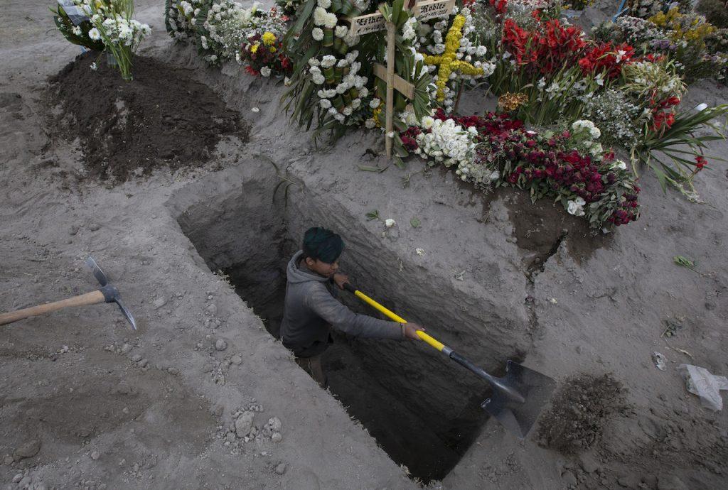 A cemetery worker digs the grave of a woman who died of complications related to Covid-19 at a cemetery outside of Mexico City, Nov 18. Photo: AP