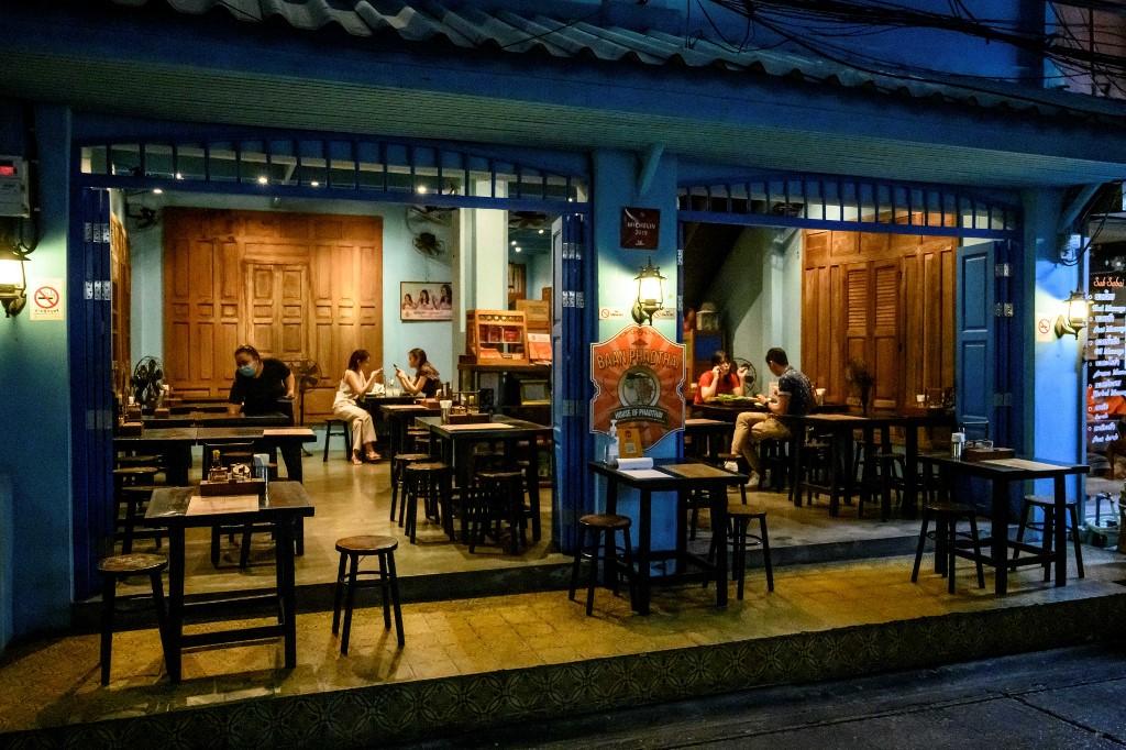 Customers sit in an almost empty restaurant in Bangkok on Nov 11. Thailand has been under a national state of emergency since last March. Photo: AFP