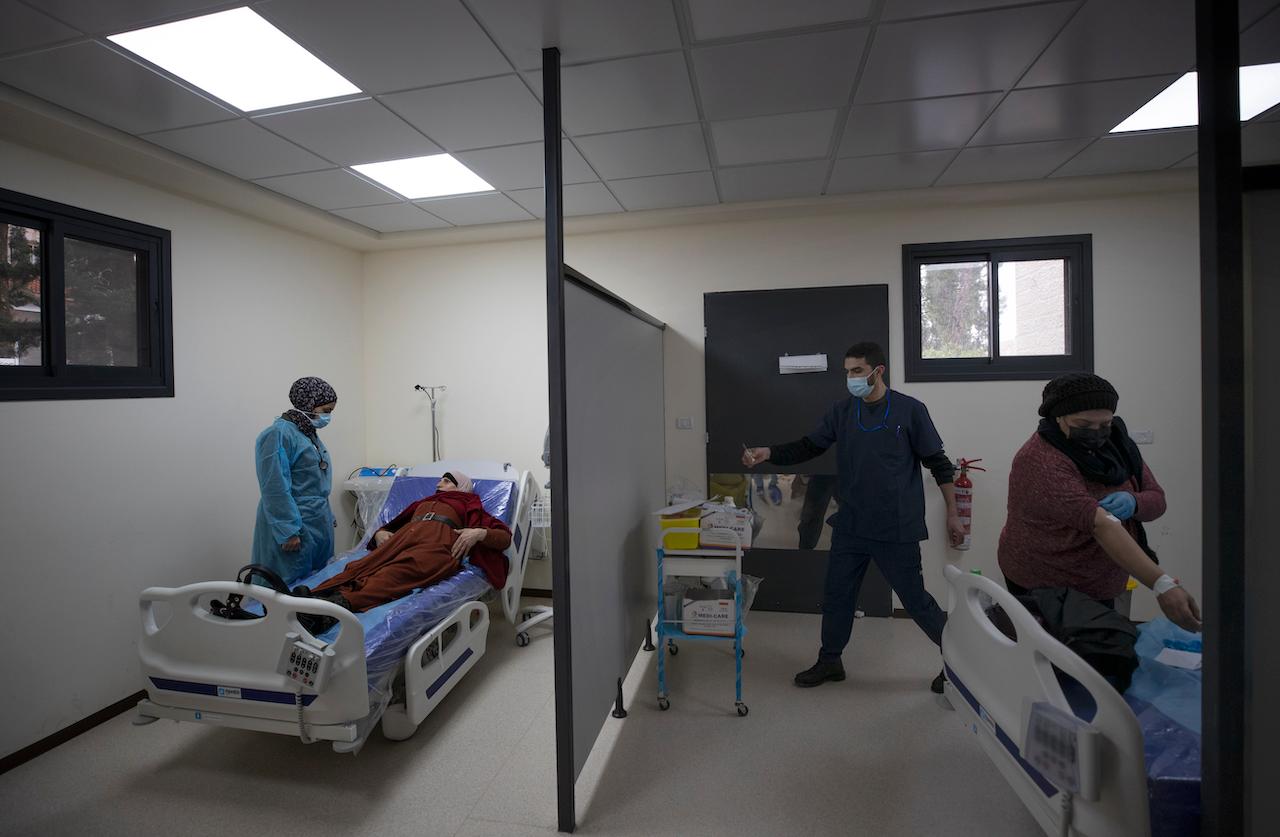 Medical staffers examine Palestinian patients infected with Covid-19 upon their admission at the emergency unit, in the Palestine Medical Complex, in the West Bank city of Ramallah, Jan 28. Photo: AP