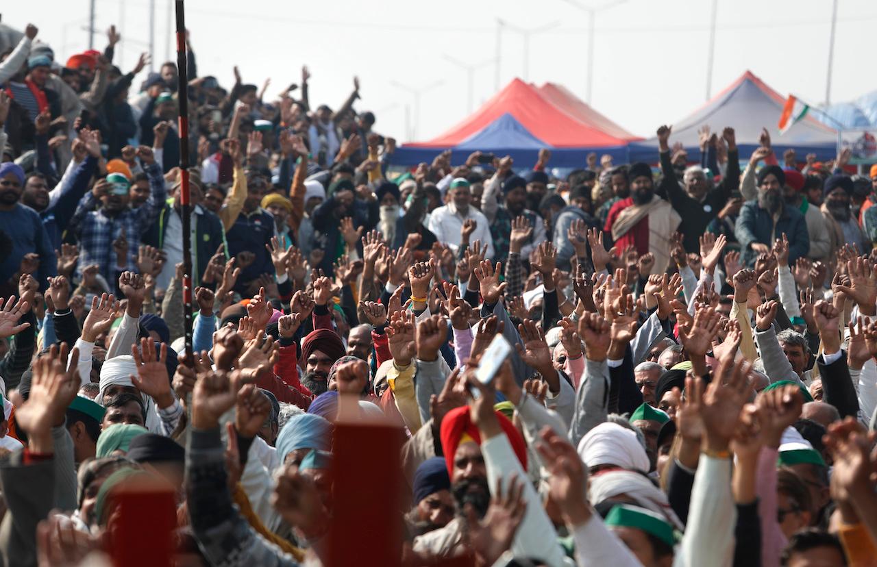 Farmers raise their hands as they shout slogans during a day-long hunger strike to protest against new farm laws, at the Delhi-Uttar Pradesh border on the outskirts of New Delhi, India, Jan 30. Photo: AP
