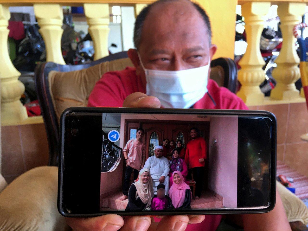Md Tarmidi Yaacob, 52, menunjukkan gambar kenangan ketika Hari Raya Aidilfitri bersama anak angkatnya yang mesra dipanggil Adik. Kanak-kanak lelaki berusia tujuh tahun itu disyaki didera hingga maut oleh ibu kandung dan bapa tirinya di rumah mereka di Taman Krubong Jaya, Melaka. Gambar: Bernama