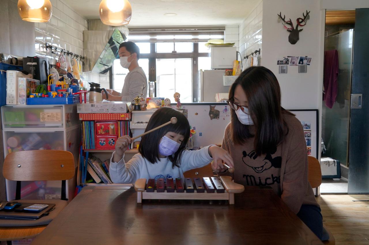 Mike, a photojournalist (left), his wife and his young daughter play at home in Hong Kong, Jan 31. The photojournalist says he plans to apply for visas and move to Leeds with his family in April. Photo: AP