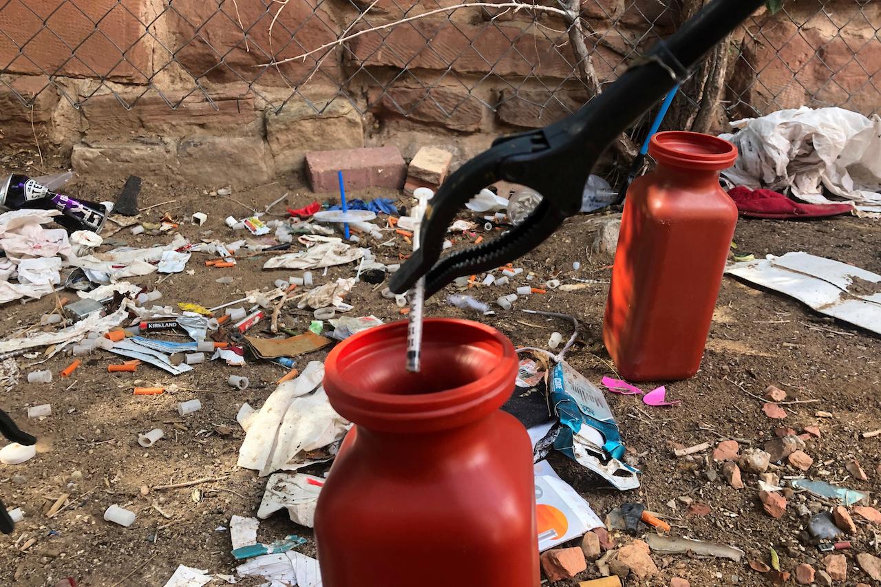 A drug syringe found behind a vacant property in New Mexico is placed in a container as part of efforts to clear the lot of needles and other heroin paraphernalia. Police in Oregon can no longer arrest someone for possession of small amounts of heroin, methamphetamine and other hard drugs as a ballot measure that decriminalised them took effect Feb 1. Photo: AP