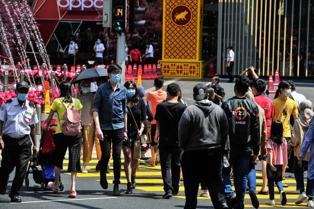 Pedestrians crossing a road in Kuala Lumpur observe health SOPs including the mandatory use of face masks to curb the spread of Covid-19. Photo: Bernama