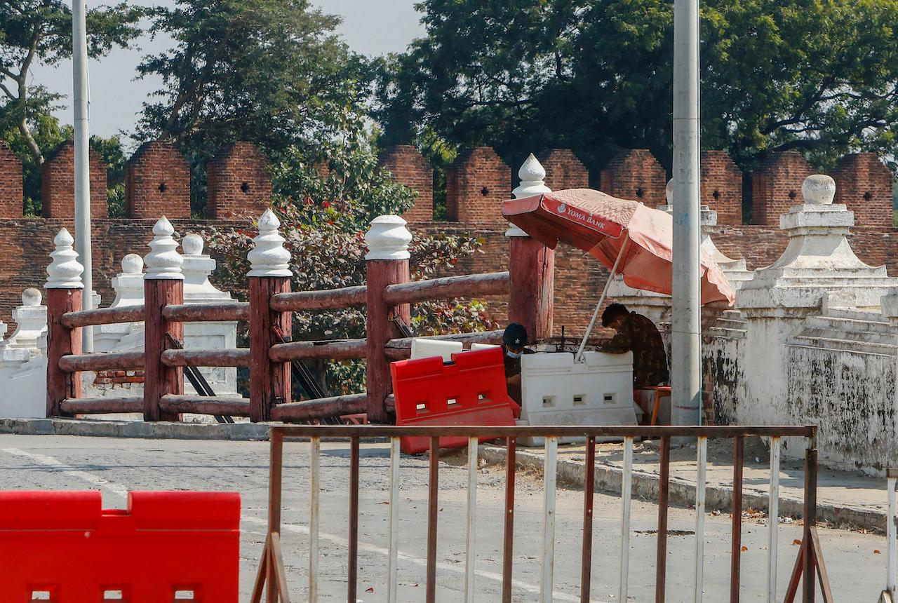 A soldier in Myanmar sits at a makeshift checkpoint at a road in Mandalay, Feb 3. Photo: AP