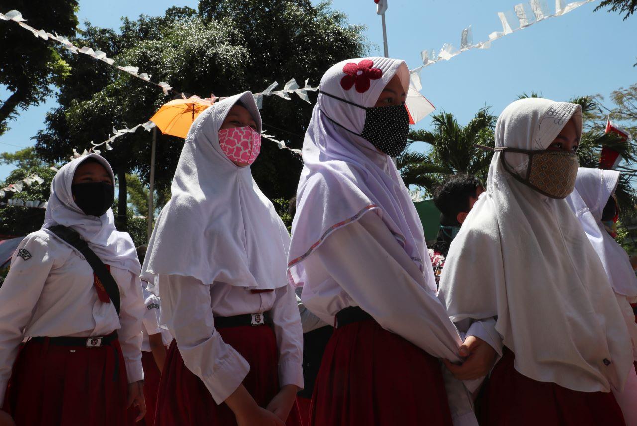 Primary school students in Jakarta, Indonesia line up on the school grounds. Schools have been banned from forcing girls to wear headscarves, with those who violate the rules to face a cut in government funding. Photo: AP