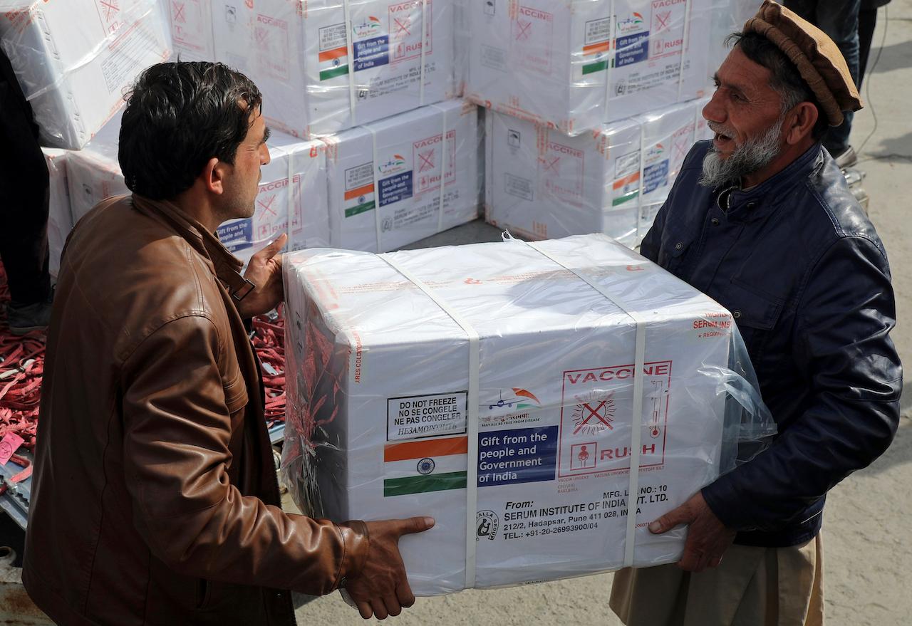 Afghan health ministry workers unload boxes of the first shipment of AstraZeneca vaccines donated by the Indian government, at the customs area of the Hamid Karzai International Airport in Kabul, Feb 7. Photo: AP