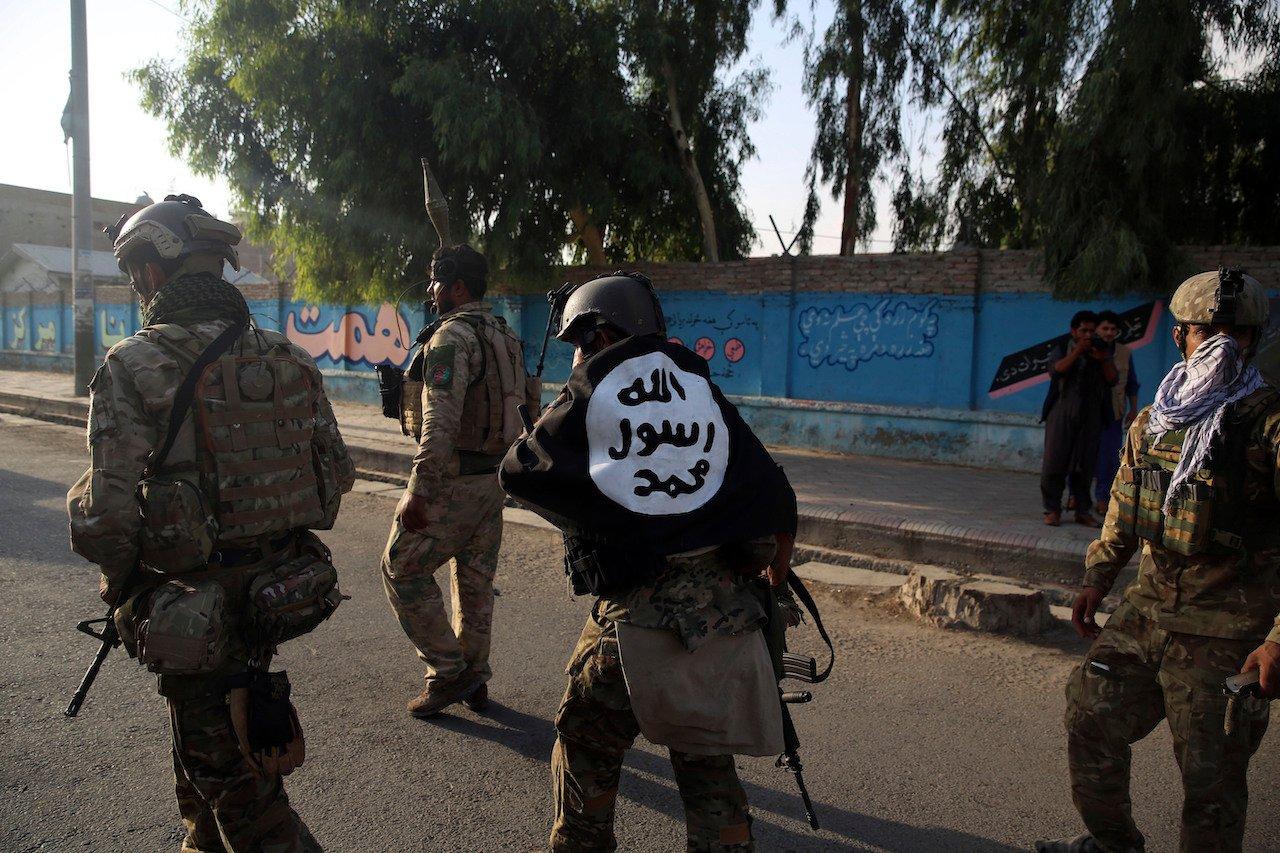 An Afghan security personnel (centre) covers himself with an Islamic State flag after an attack in the city of Jalalabad, east of Kabul, Afghanistan, Aug 3, 2020. Singapore has deported a Malaysian who had planned to join the IS group in Syria. Photo: AP
