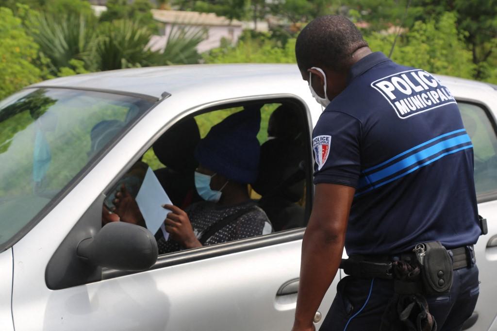 Polis Perancis memeriksa dokumen perjalanan dalam satu sekatan jalan raya di Mamoudzo. Gambar: AFP