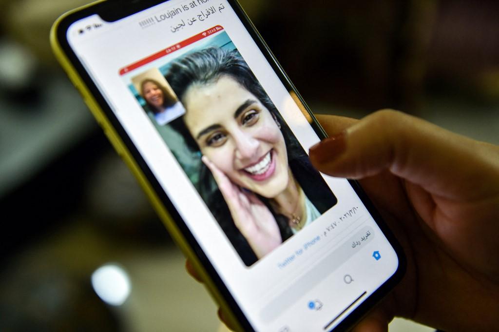 A woman views a tweet posted by the sister of Saudi activist Loujain al-Hathloul, showing a screenshot of them having a video call following Loujain's release after nearly three years in detention. Photo: AFP