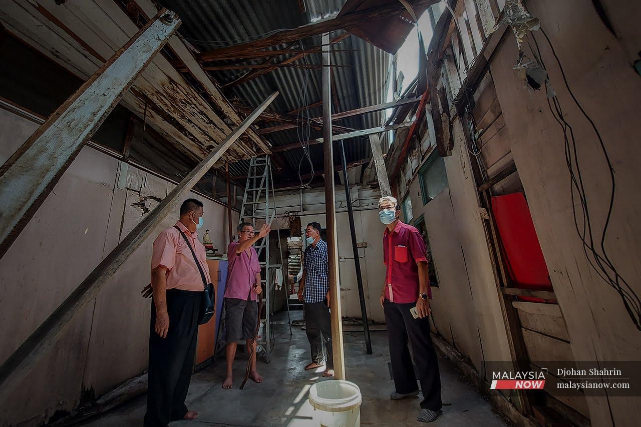 Chin Kim Choy (second left) gestures as he shows Ampang Chinese community representative Fong Teck Keong and several others around his house in Kampung Baru Ampang. Concern that the roof would collapse on the family have been allayed by news that the entire house will soon be refurbished.
