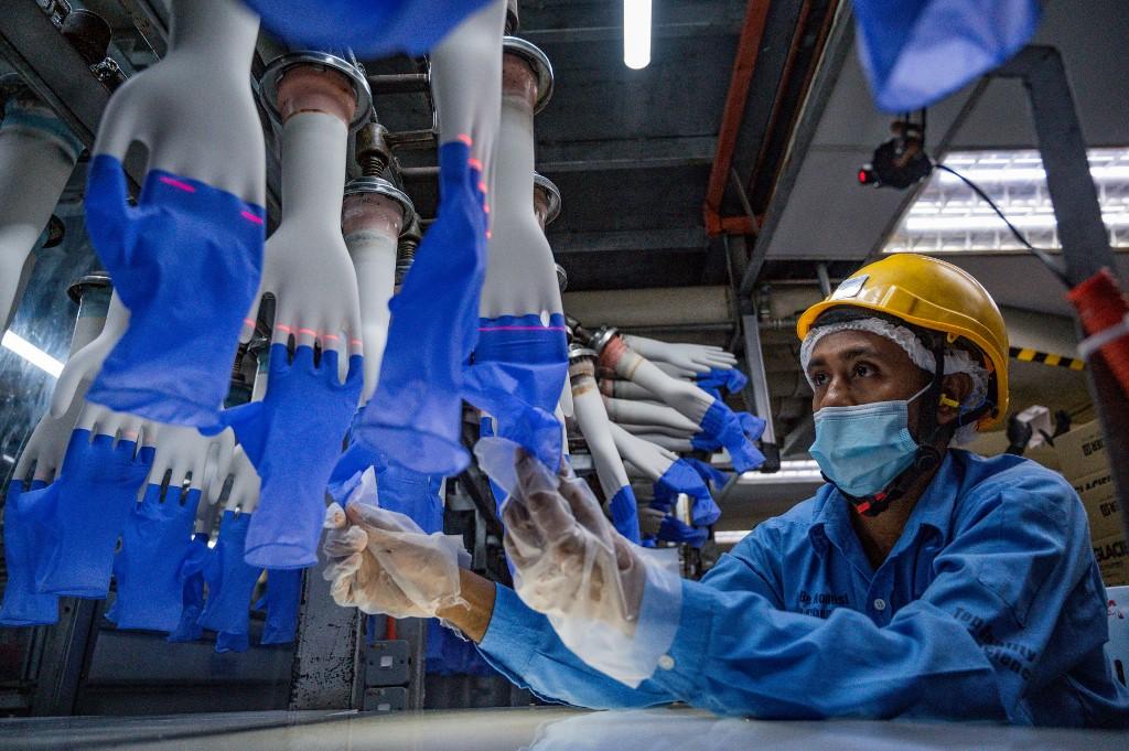 Gambar dirakam pada 26 Ogos 2020, menunjukkan seorang pekerja kilang Top Glove sedang memeriksa sarung tangan keluaran syarikat itu.Gambar: AFP