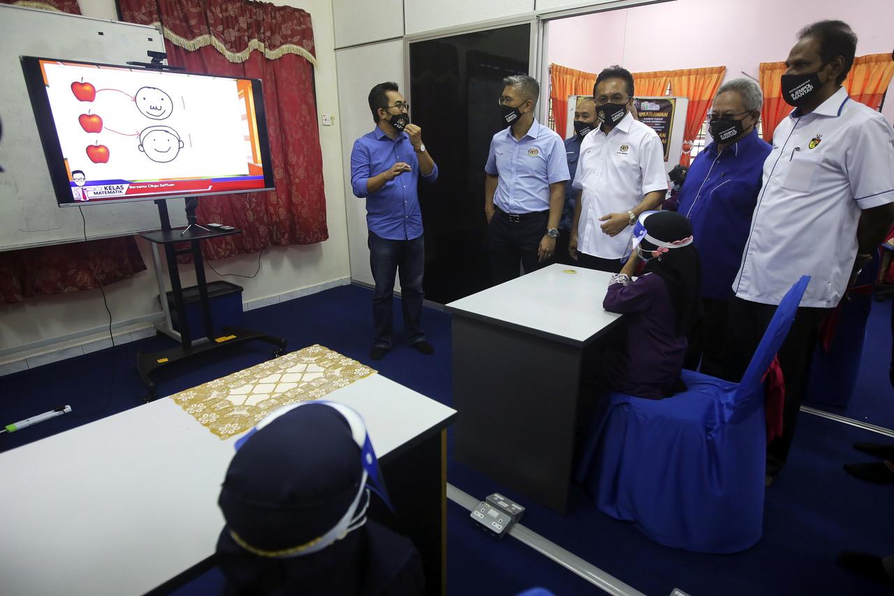 Menteri Kewangan, Tengku Zafrul Aziz (empat, kanan) mendengar penerangan dari Pengarah Program Pembelajaran Digital dan Multimedia Khairul Annuar Mansor (lima, kanan) semasa mengadakan lawatan di Pusat Komuniti Desa Kampung Serting di Jempol, hari ini. Gambar: Bernama