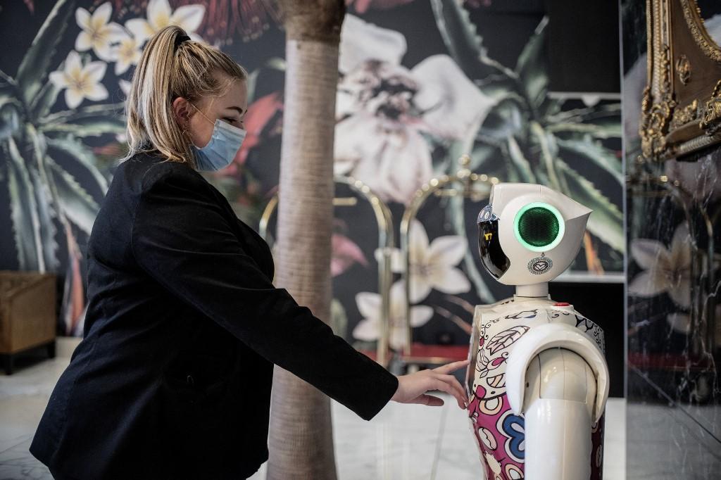 A receptionist asks for information from a robot by CTRL Robotics company in the hall of the Sky Hotel in Sandton, South Africa, Jan 29. Photo: AFP