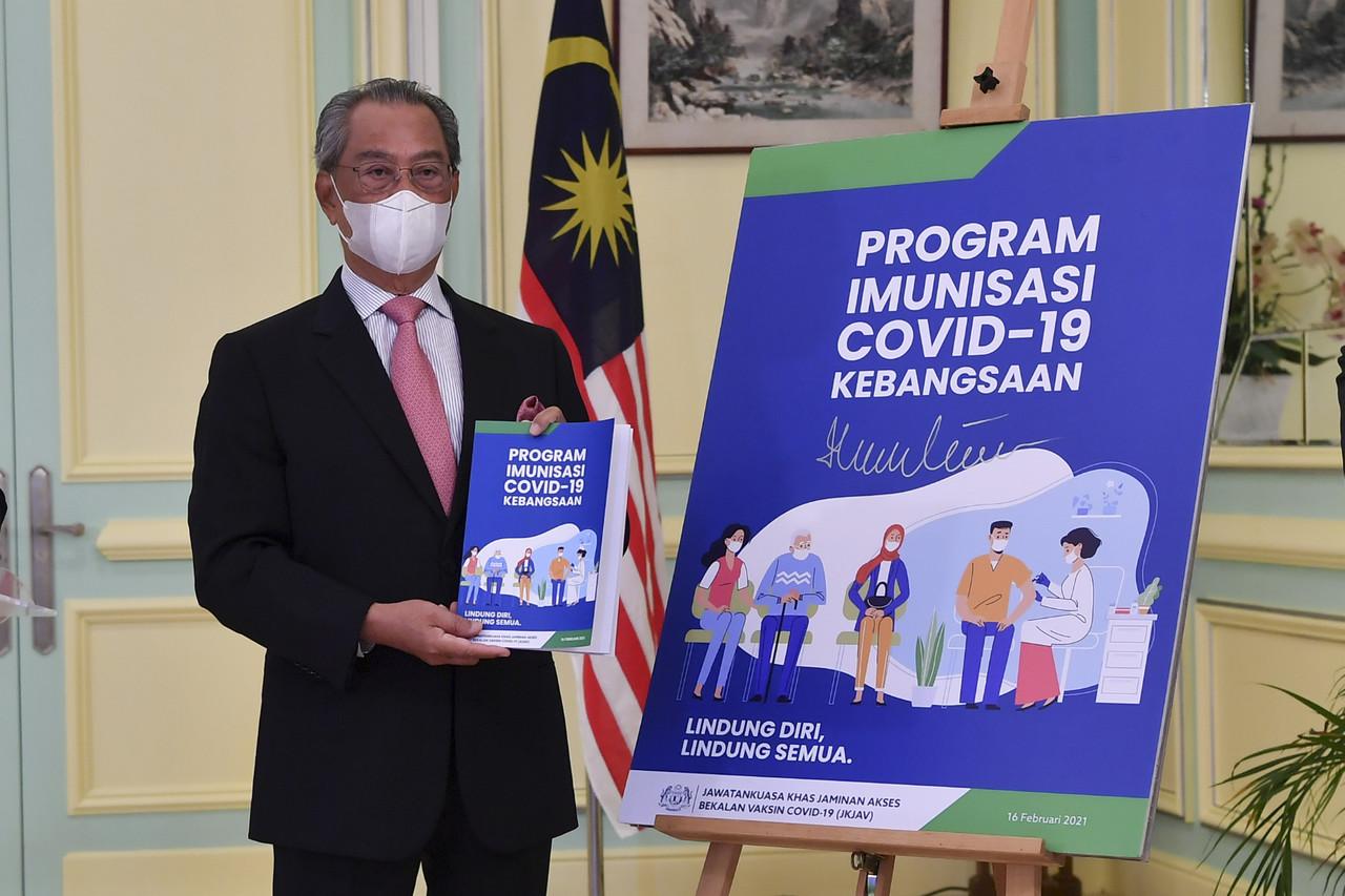Prime Minister Muhyiddin Yassin launches the National Covid-19 Immunisation Programme Handbook in Putrajaya today. Photo: Bernama