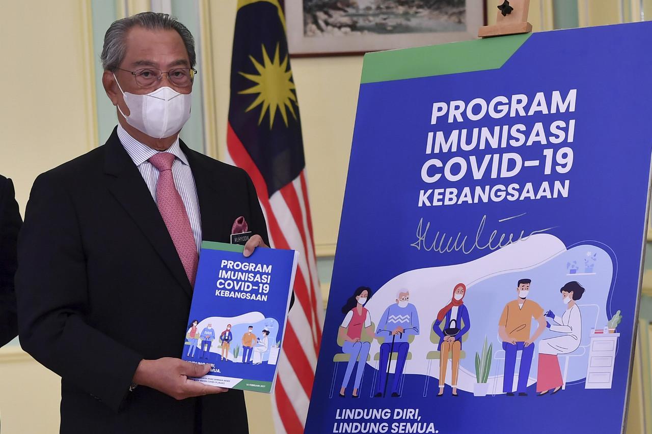 Perdana Menteri Muhyiddin Yassin ketika melancarkan Buku Panduan Program Imunisasi Covid-19 Kebangsaan di Bangunan Perdana Putra hari ini. Gambar: Bernama