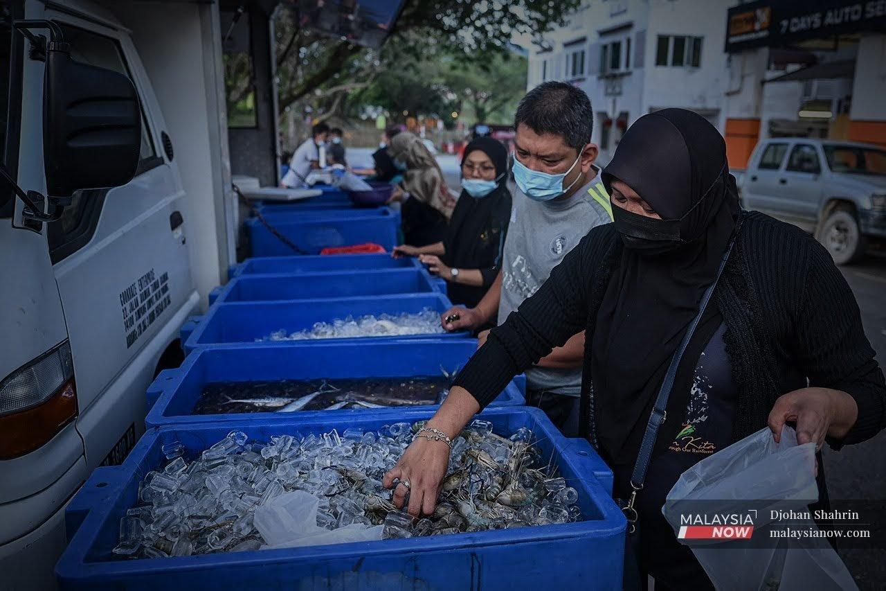 Penduduk sekitar Desa Melawati memilih ikan-ikan segar yang ditawarkan Kiki Fish Market di Klang Gate, Hulu Klang.
