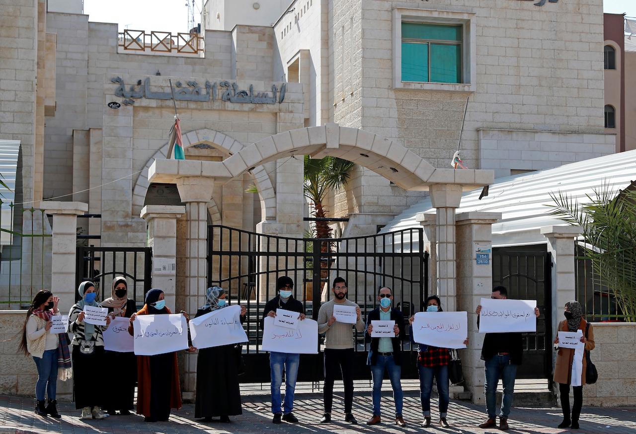 People hold signs during a protest against the decision by the Sharia Judicial Council banning women from movement in and out of the Gaza Strip without the permission of a 'guardian', in front of the council, in Gaza City, Feb 16. Photo: AP