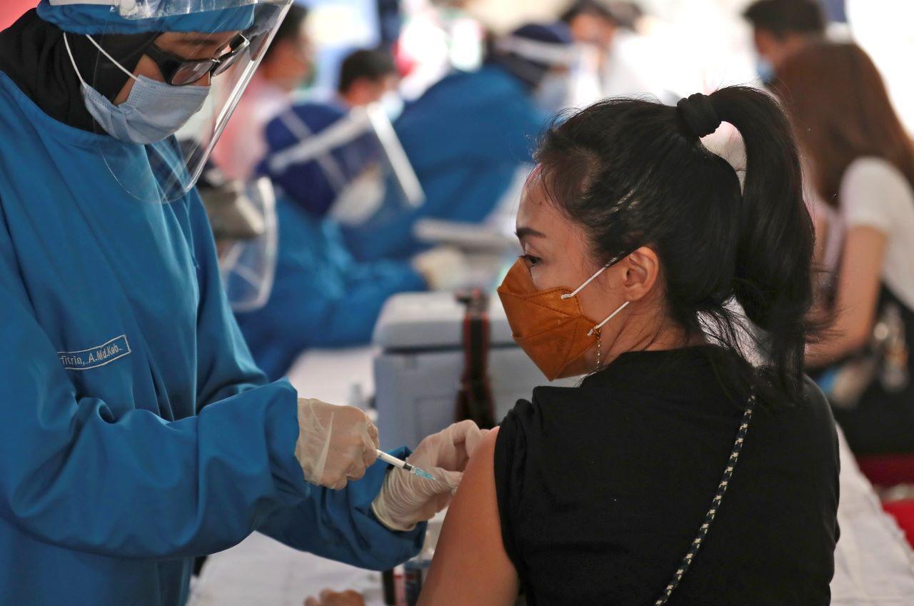 A woman receives a shot of Covid-19 vaccine during a mass vaccination for traders and workers at Tanah Abang Market in Jakarta, Indonesia. Photo: AP