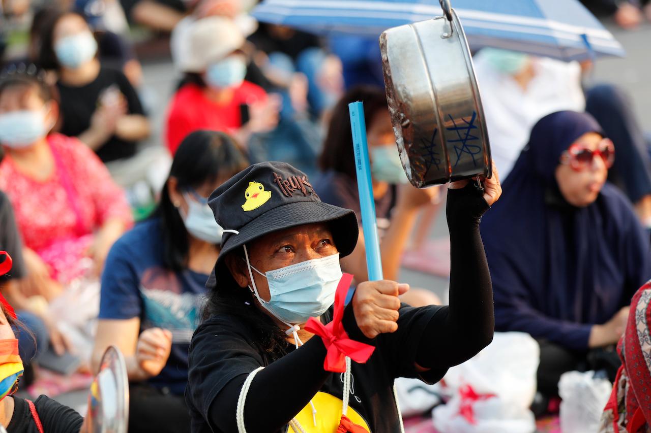 A pro-democracy protester bangs a metal pan to make noise during a rally at Democracy Monument in Bangkok, Thailand, Feb 13. Photo: AP