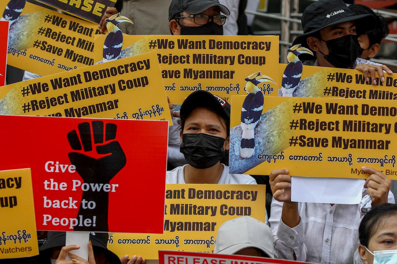 Demonstrators display placards during a protest against the military coup in Yangon, Myanmar, Feb 18. Photo: AP