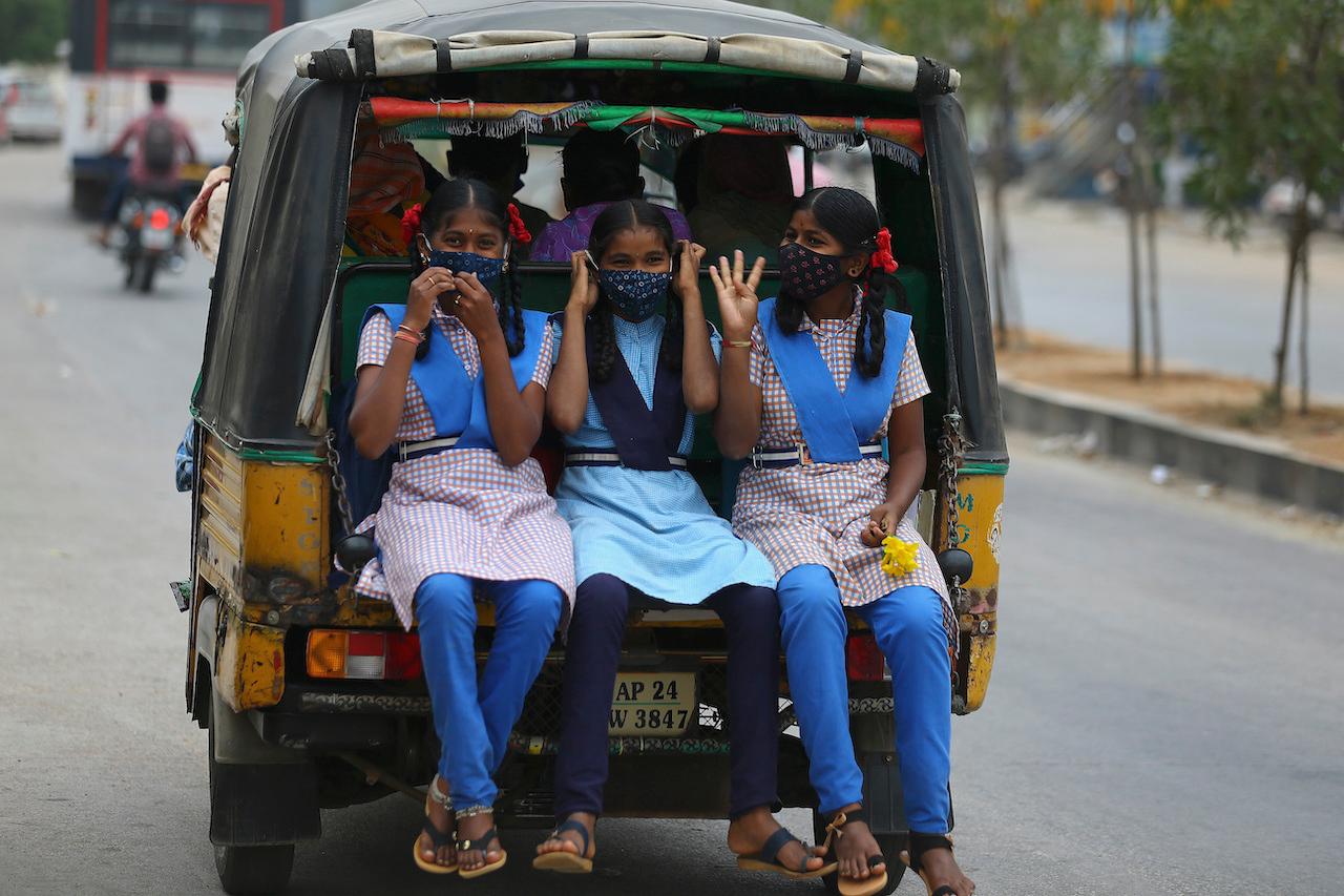 Schoolchildren wearing face masks as a precaution against Covid-19 travel in an auto rickshaw on the outskirts of Hyderabad, India, Feb 19. Photo: AP
